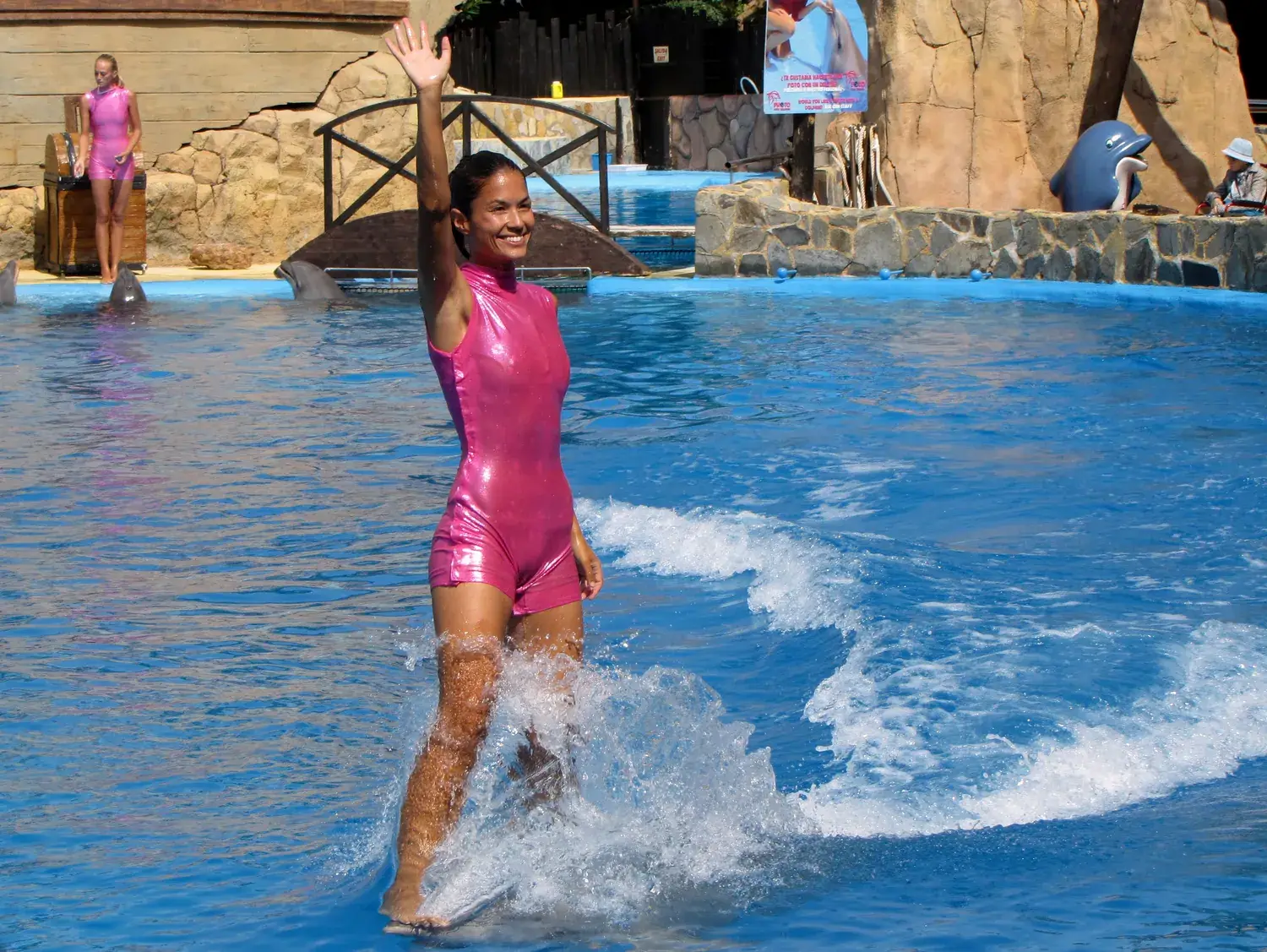 Cuidadora y delfín en la piscina de Mundomar durante una exhibición