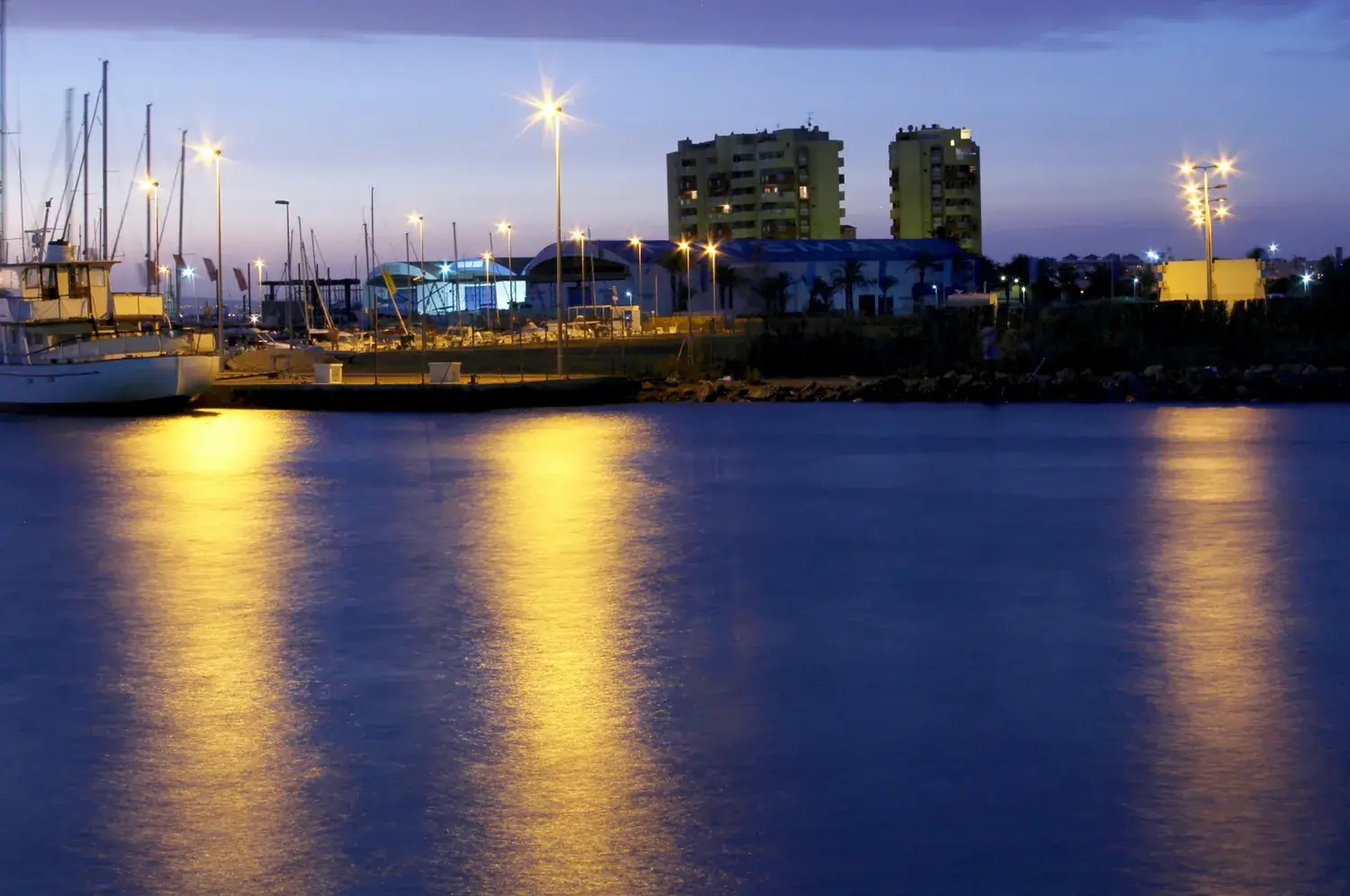 De haven van La Manga ’s nachts verlicht, met reflecties in het water