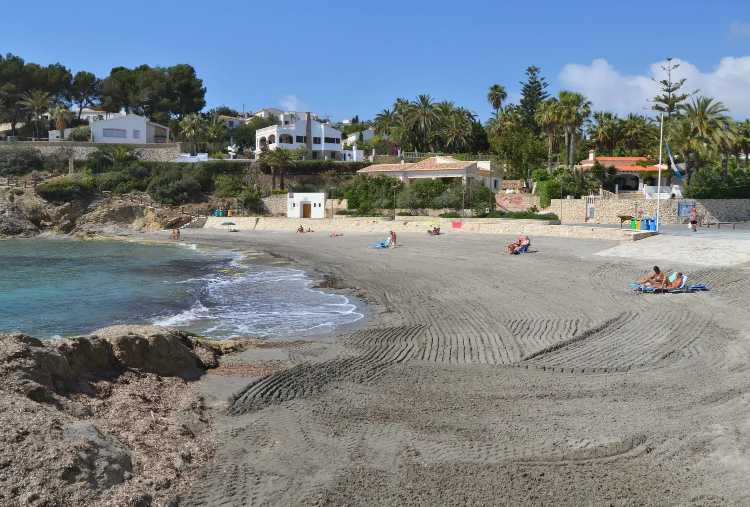 La plage de sable de la cala de la Fustera à Benissa, entourée de pins et de maisons