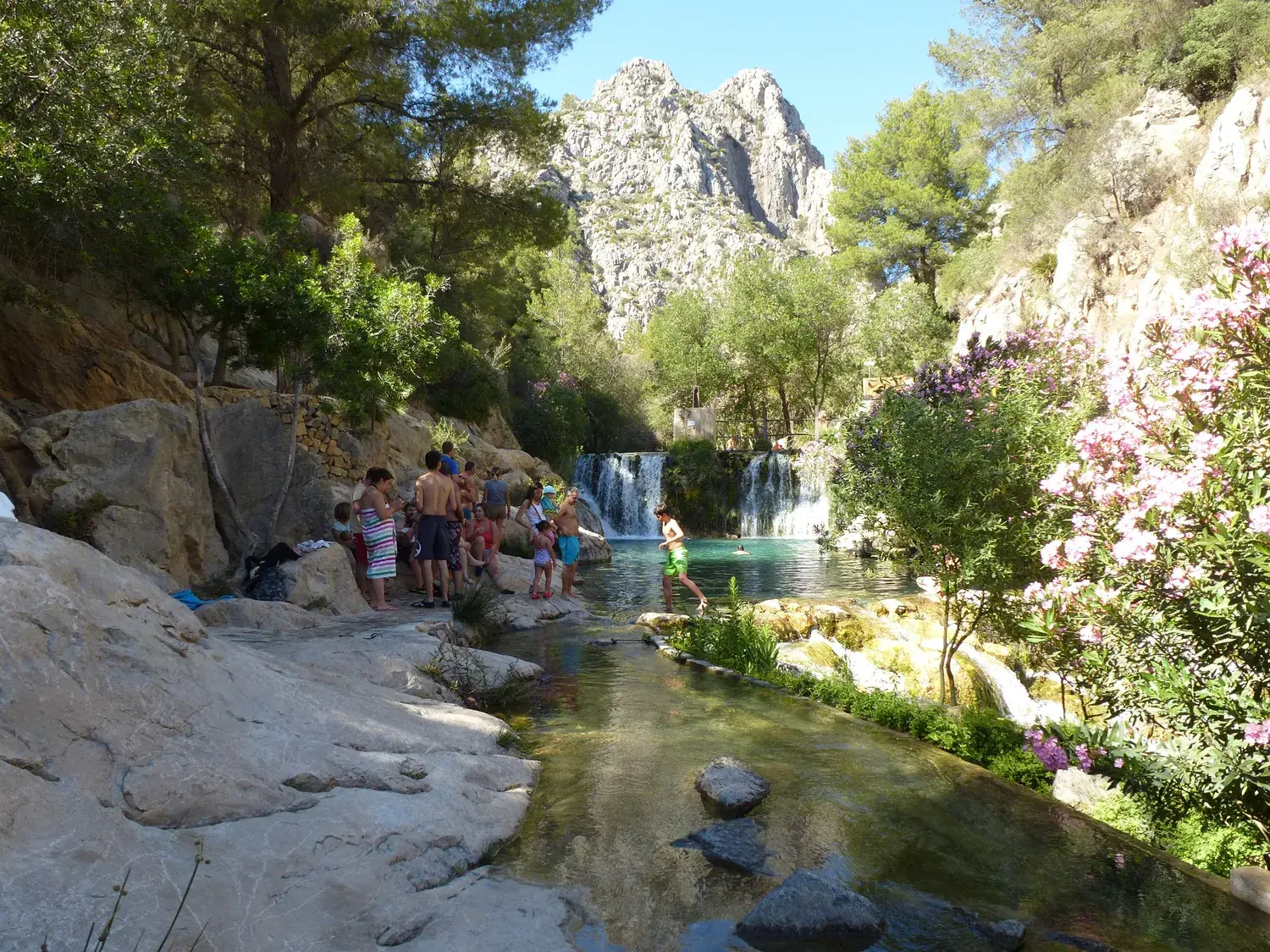 Baigneurs dans une vasque naturelle au pied d’une petite cascade