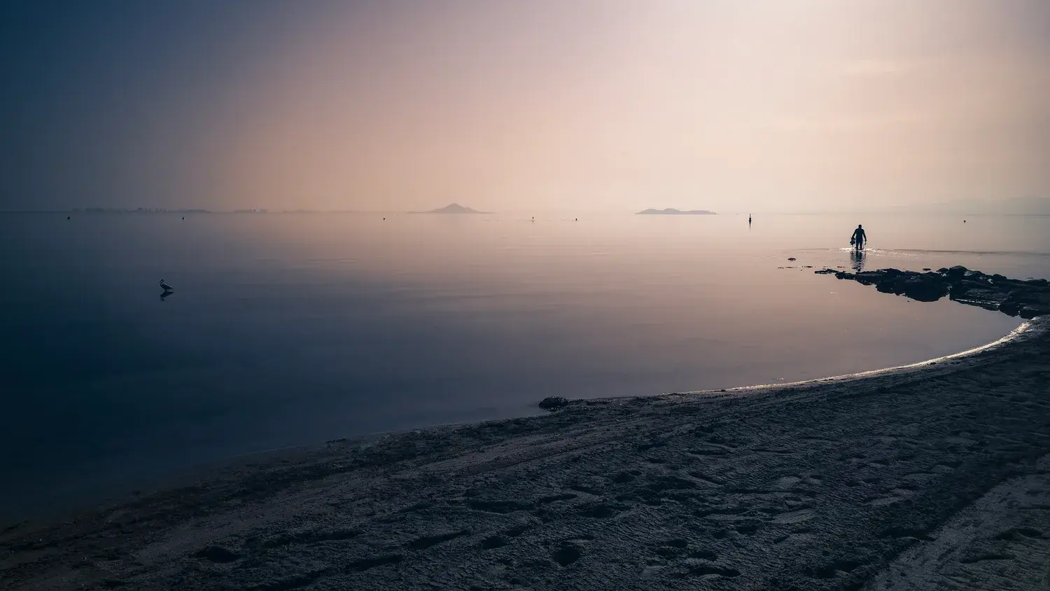 The calm Mar Menor at sunset, smooth water and a hazy horizon