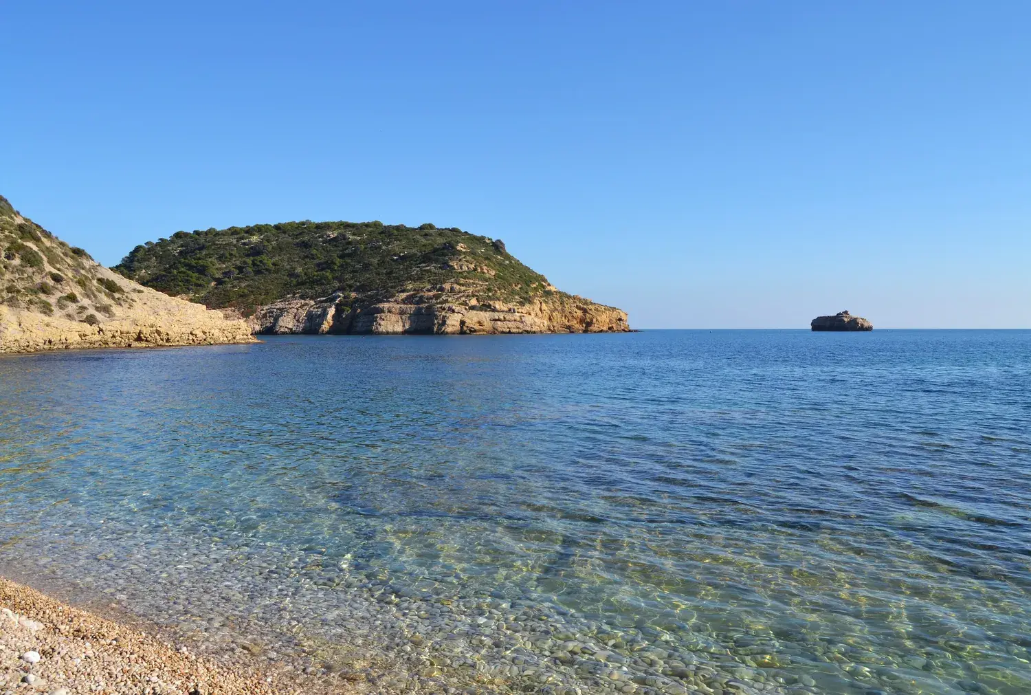 L’île du Portitxol face à la crique de la Barraca à Xàbia, mer calme et transparente