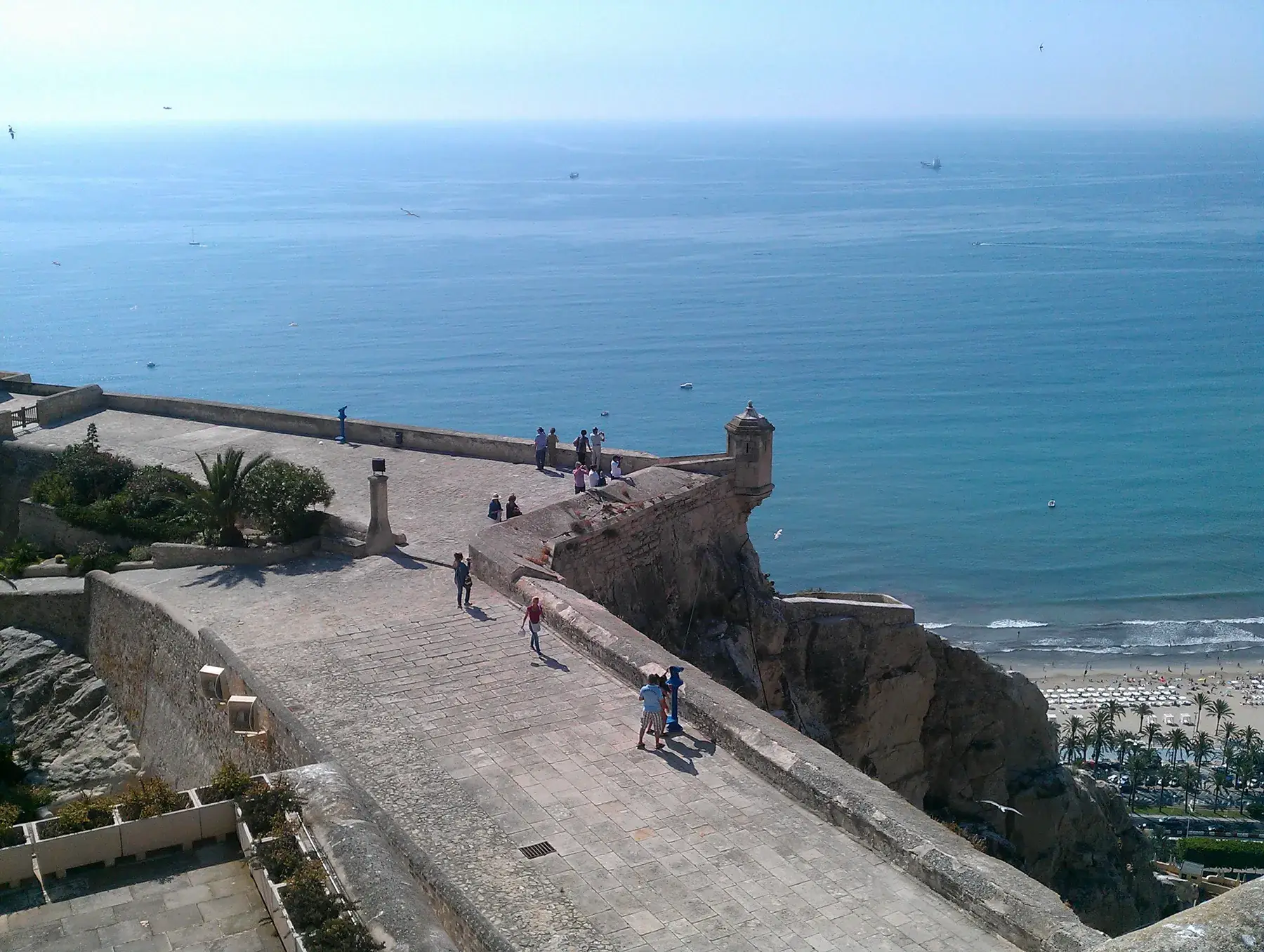 De muren van het kasteel van Santa Bárbara boven de zee en het strand van Alicante