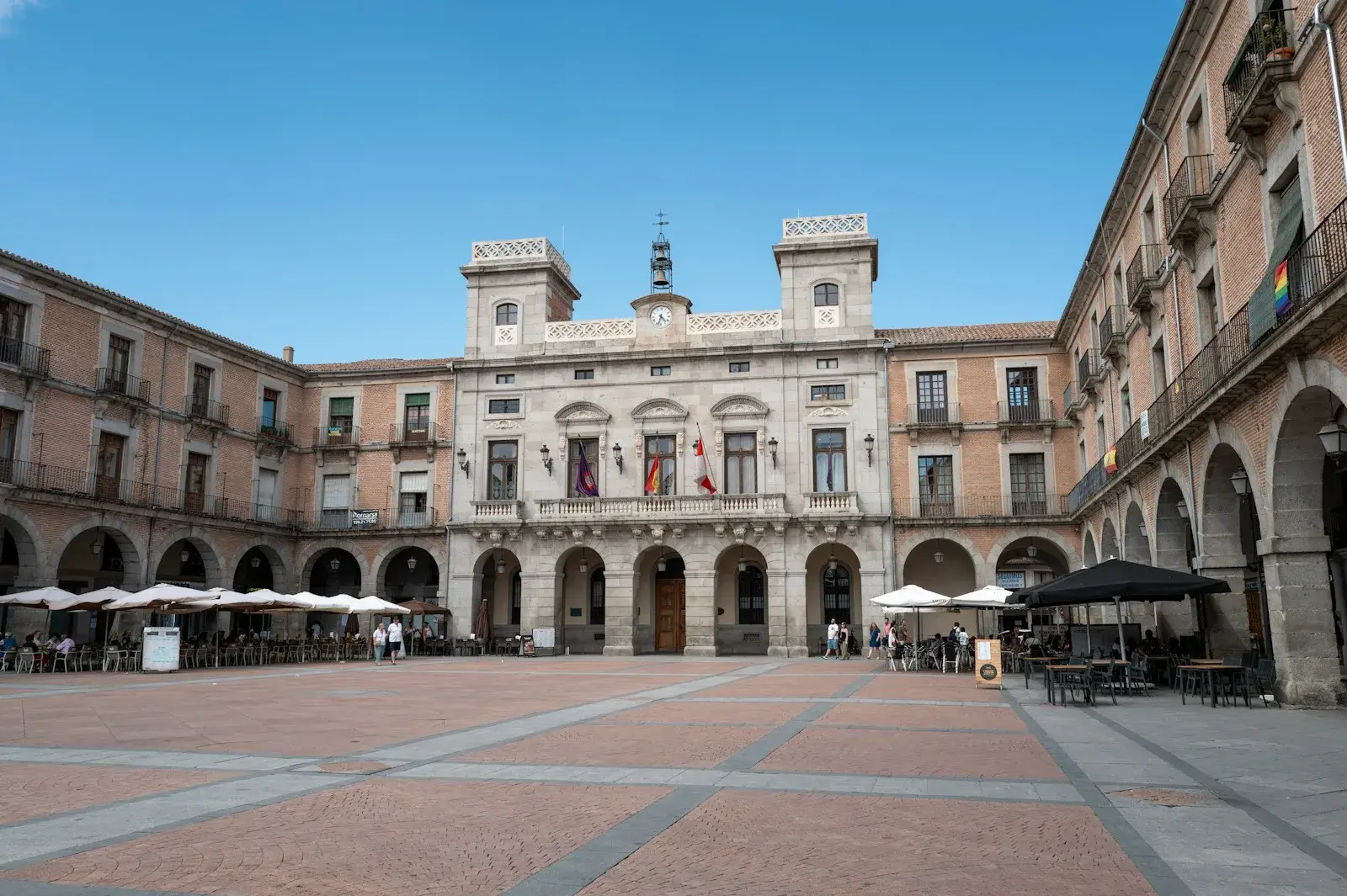 Sunny main square lined with arcades in front of the town hall