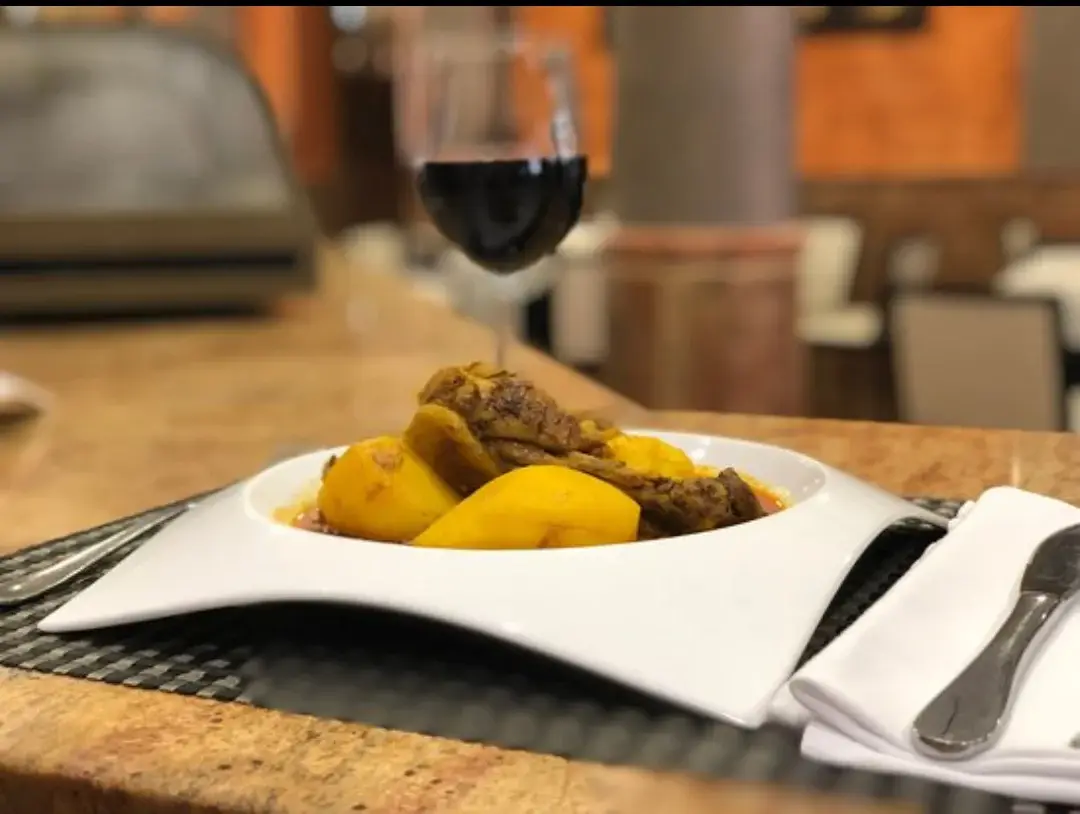 Dish served at Punto Caliente restaurant in Benejúzar, with a glass of red wine