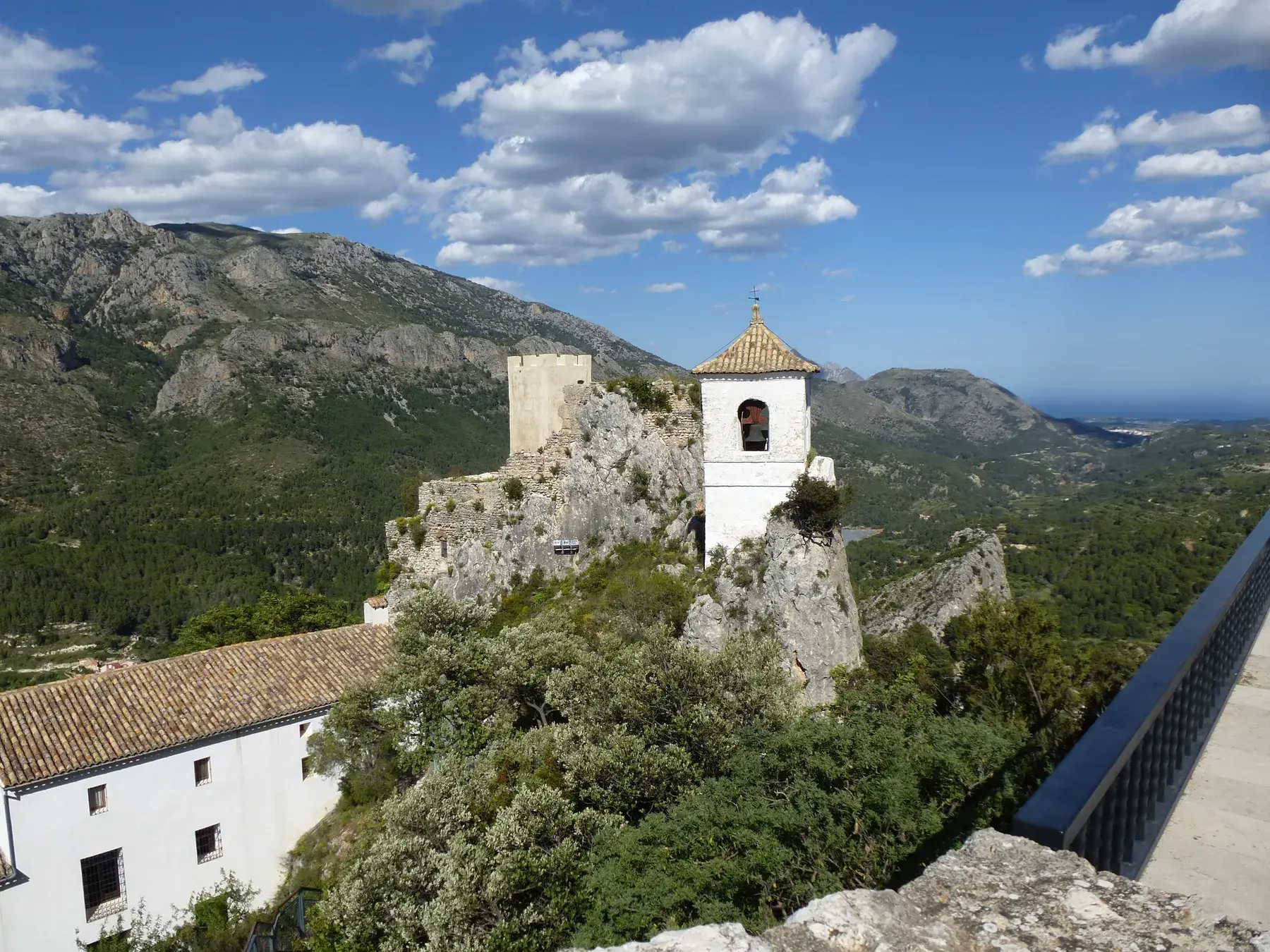 Guadalest’s white bell tower perched on its rock, with the valley and reservoir below