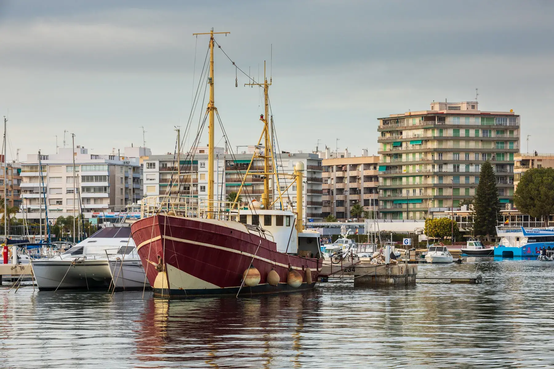 Santa Pola marina, with moored boats and an old fishing sailboat